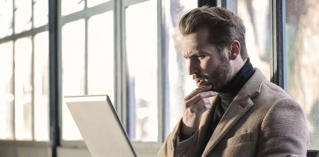 Man with serious look looking at laptop