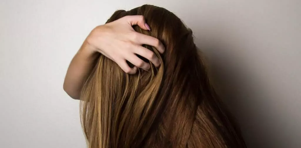 woman covering face with her hair