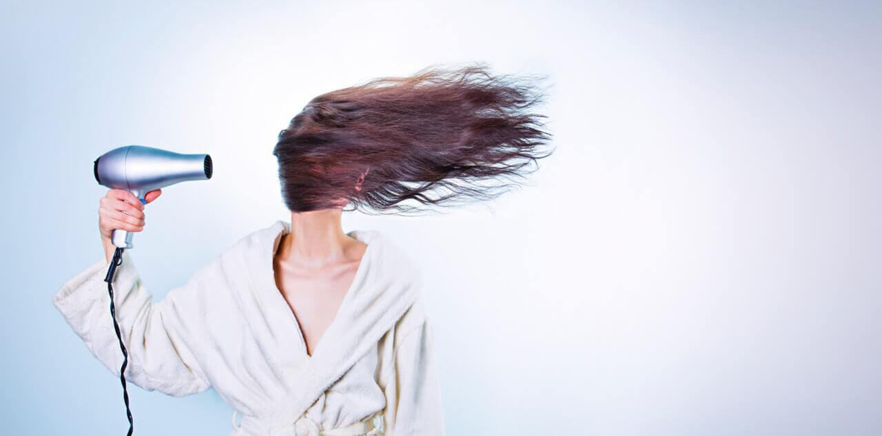 Women blow drying hair, female hair loss treatments
